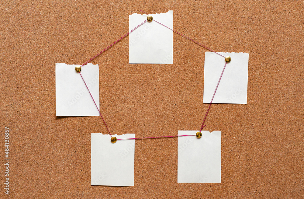 Blank paper notes are pinned to a cork board. The concept of detective investigation. Copy space. Blank paper notes are pinned to a cork board. The concept of detective investigation. Copy space.