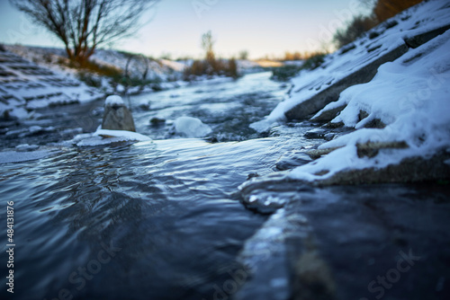 Close-up of a running river during sunset in winter