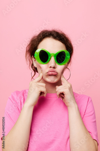 Stylish teenager girl model with green glasses decoration gesture with his hands © Tatiana