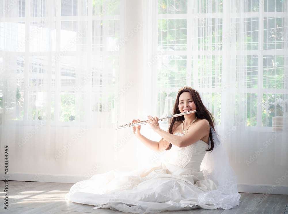 A charming female flutist performs on her instrument. A young and elegant Asian woman plays the flute. A charming female flutist performs on her instrument. A young and elegant Asian woman plays the flute.