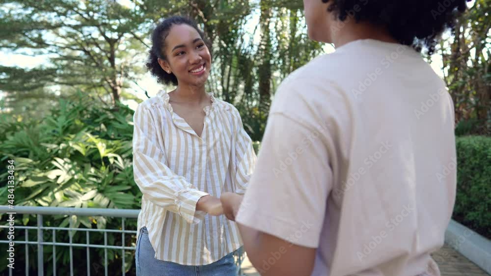 Friendship two young beautiful smiling girls and talking in the garden Friendship two young beautiful smiling girls and talking in the garden