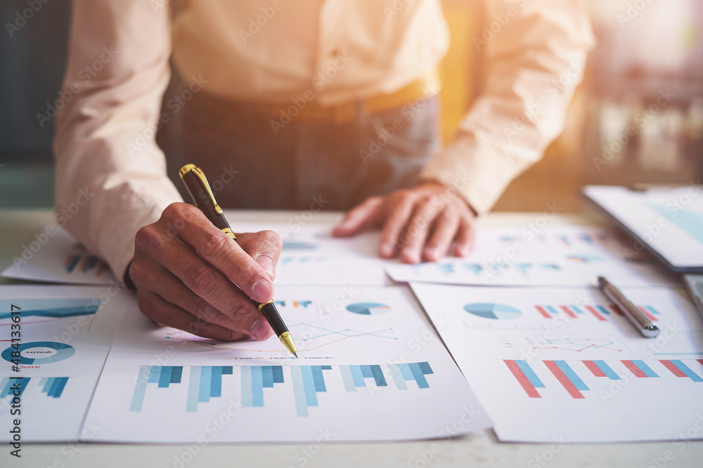 Close up hands of businessman analysis financial chart and graph on table desk. Close up hands of businessman analysis financial chart and graph on table desk.
