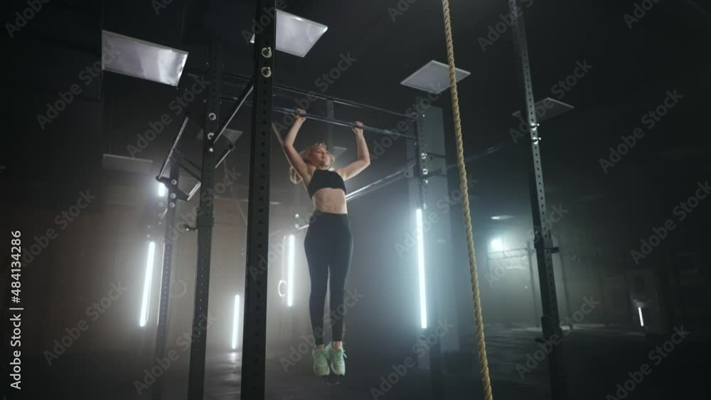 Vídeo do Stock: A sporty young woman pulls herself up on a horizontal ...