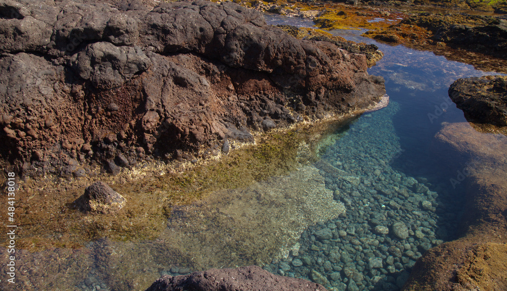 Gran Canaria, calm rock pools under steep cliffs of the north coast are 
separated from the ocean by volcanic rocks of platform constructed by old lava flows
Punta de Galdar area