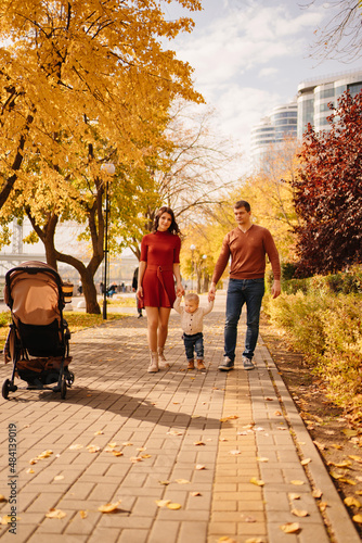a family with a child on an autumn walk around the city