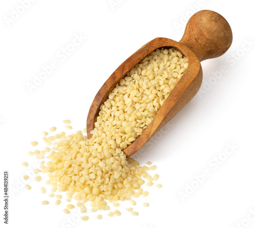 Hulled hemp seeds in the wooden scoop, isolated on white background.