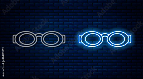 Glowing neon line Glasses for swimming icon isolated on brick wall background. Swimming goggles. Diving underwater equipment. Vector