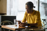 African american woman using a smartphone while sitting in a cafe
