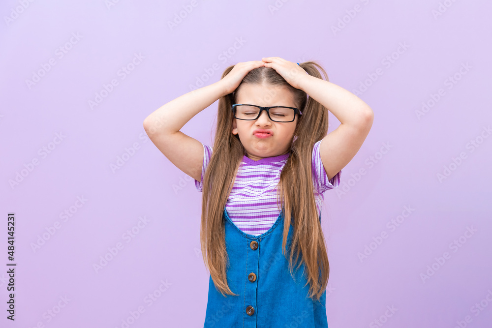 The outraged child holds his head with his hands and wrinkles his face and is mischievous. The outraged child holds his head with his hands and wrinkles his face and is mischievous.