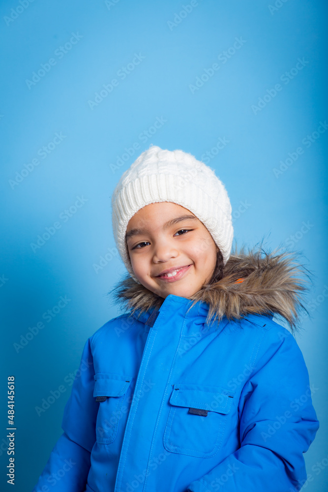 portrait on blue background of young Asian girl with smile looking at camera portrait on blue background of young Asian girl with smile looking at camera