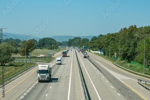 High-speed road with trucks and cars on the background of blue skies and mountains. The M4 Don highway in southern Russia.