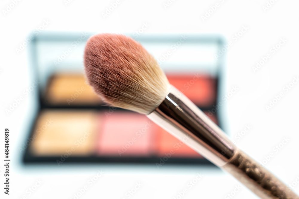 Make-up brush close-up in front of a make-up palette Make-up brush close-up in front of a make-up palette