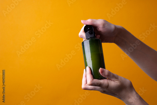package of lotion or shampoo in female hands