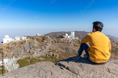 Hiker young boy over looking Aravalli Range with guru shikhar Mount Abu, Rajasthan.