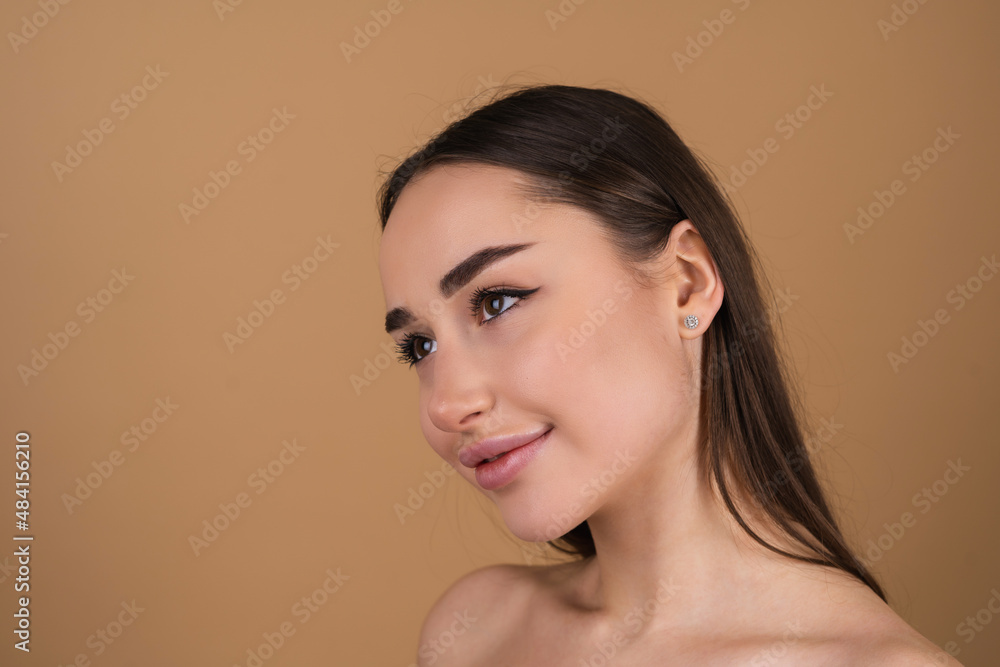 Close beauty portrait of a topless woman with perfect skin and natural makeup, shiny lips, on a beige background Close beauty portrait of a topless woman with perfect skin and natural makeup, shiny lips, on a beige background