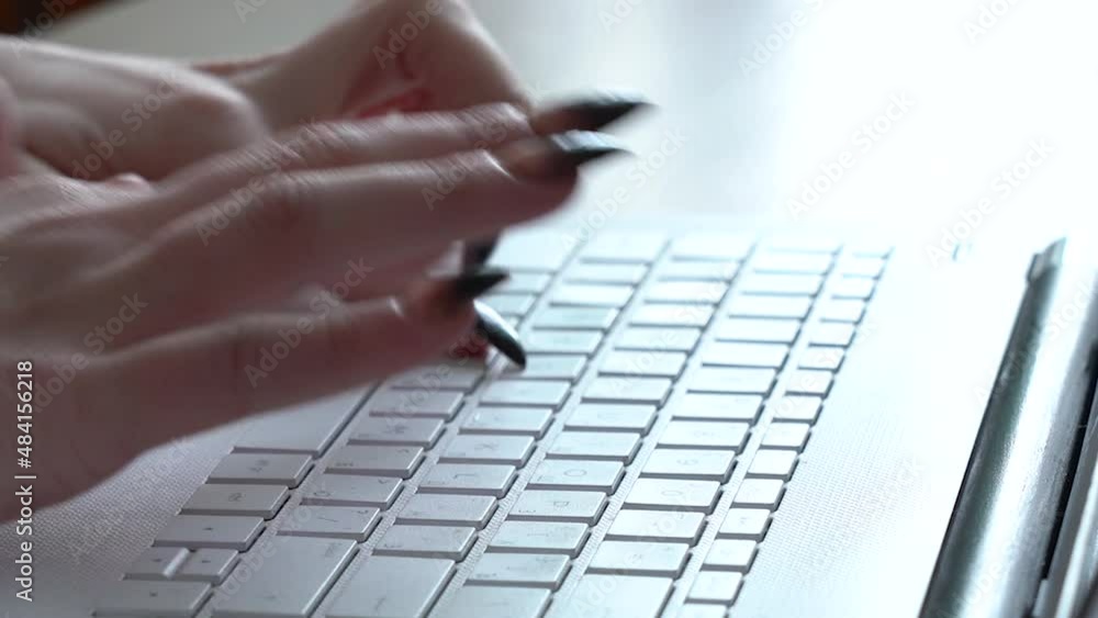 Female hands of a woman typing on a laptop keyboard while sitting at her desk Female hands of a woman typing on a laptop keyboard while sitting at her desk
