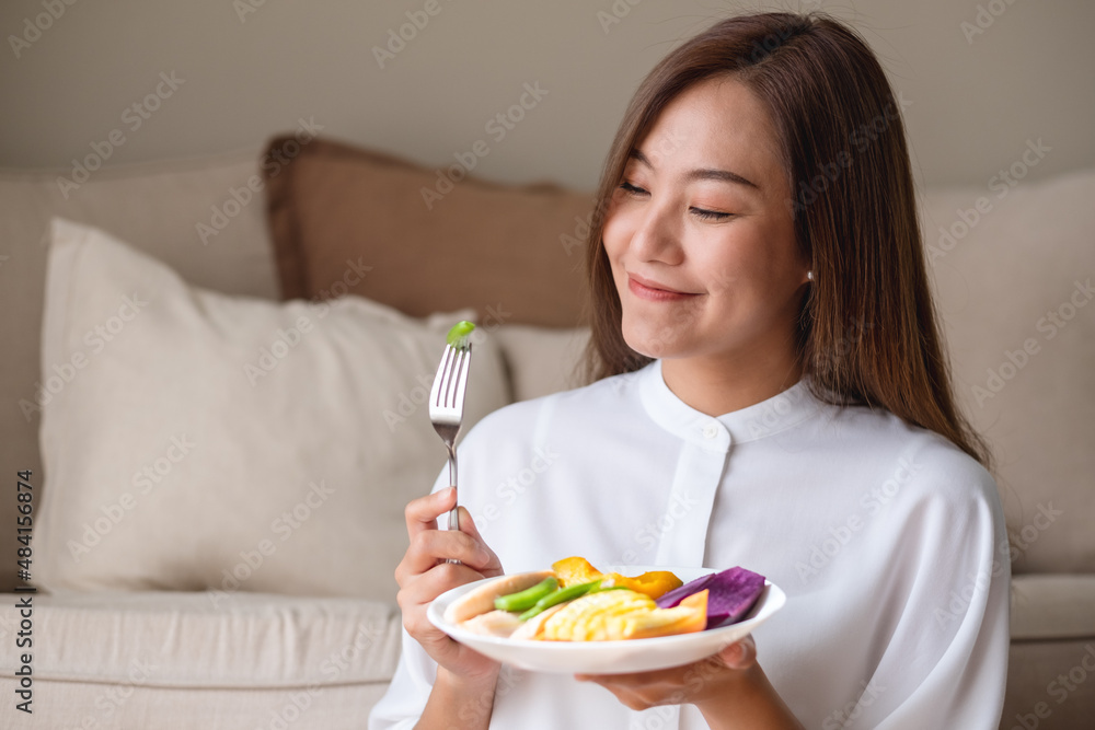 Portrait image of a young woman eating vegetables, Vegan, clean food, dieting concept