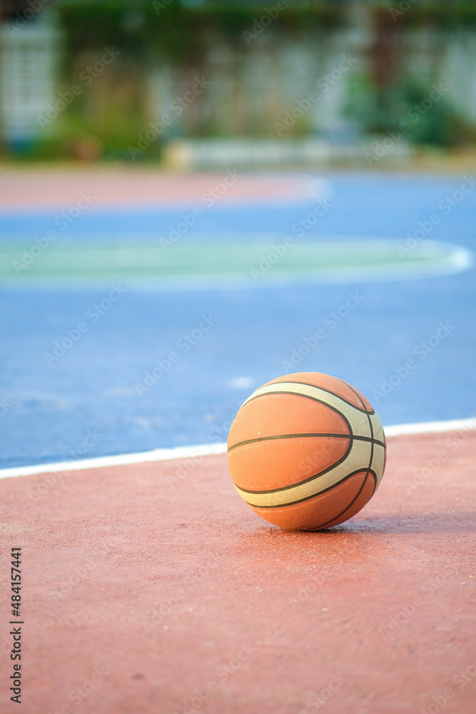 photo of basketball ball on outdoor court placed on a colorful field It is a team sport. Use precision and speed, have space for text