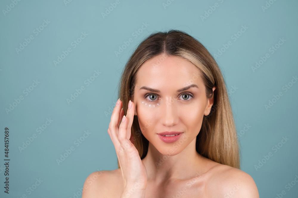 Close-up beauty portrait of a topless woman with perfect skin and natural make-up, with anti-aging cream dots to moisturize and firm the skin under the eyes. Close-up beauty portrait of a topless woman with perfect skin and natural make-up, with anti-aging cream dots to moisturize and firm the skin under the eyes.