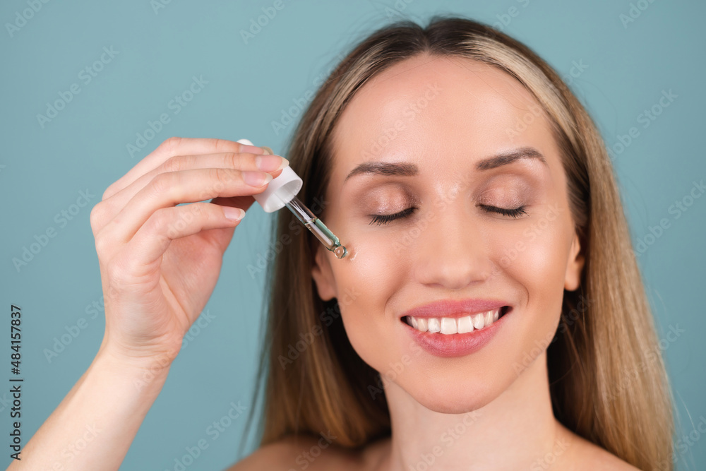 Close beauty portrait of topless woman with perfect skin and natural make-up, holds serum for youth and skin hydration, dropper with cosmetic oil. Close beauty portrait of topless woman with perfect skin and natural make-up, holds serum for youth and skin hydration, dropper with cosmetic oil.