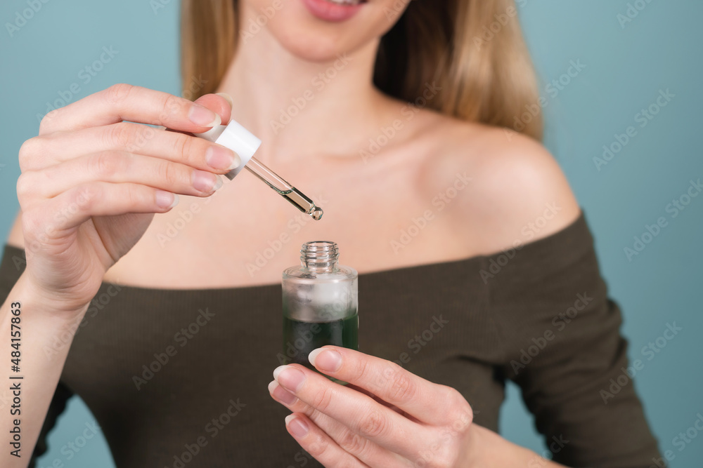 Close beauty portrait of topless woman with perfect skin and natural make-up, holds serum for youth and skin hydration, dropper with cosmetic oil. Close beauty portrait of topless woman with perfect skin and natural make-up, holds serum for youth and skin hydration, dropper with cosmetic oil.