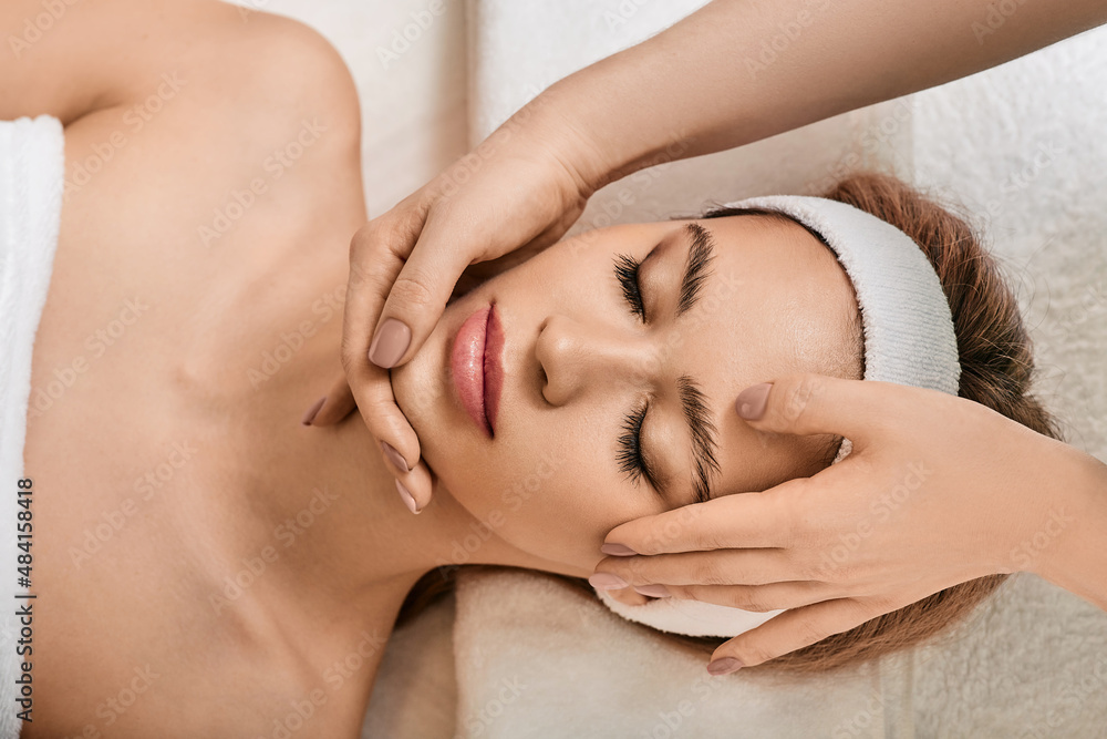 Facial massage. Beautiful woman during face massage for lifting face skin and facial elastic in wellness spa Facial massage. Beautiful woman during face massage for lifting face skin and facial elastic in wellness spa