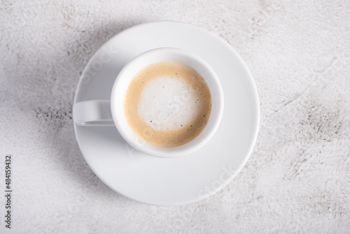 A cup of espresso macchiato on a light background for breakfast