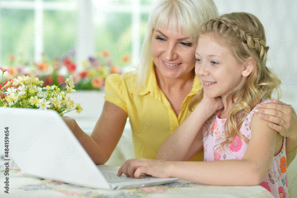 mother and daughter looking at laptop computer mother and daughter looking at laptop computer