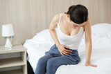Cystitis in a woman. A young woman has a pain in the lower abdomen, she holds her stomach with her hand.