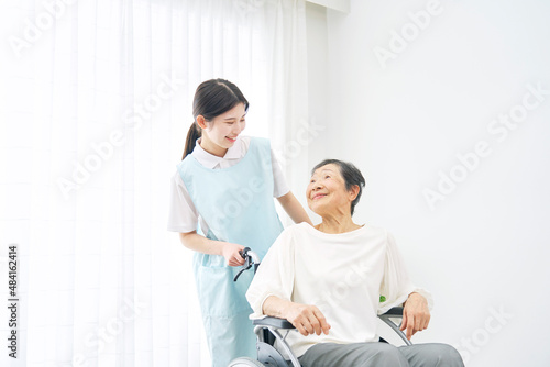 介護士と車椅子に乗る高齢者　会話　室内