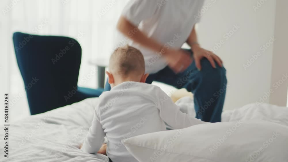 Cheerful mother and son jumping on the bed at home Cheerful mother and son jumping on the bed at home