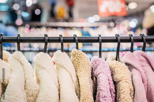 Fotografie Multicolored youth faux fur coats on clothes rack in shop, assortment in clothing store