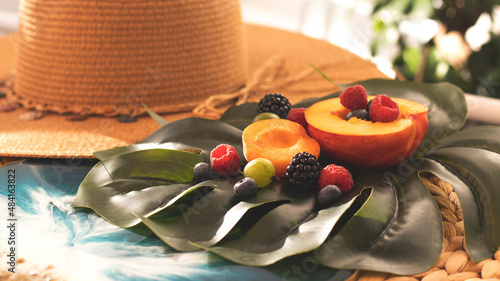 Summer fruity berry background. Table with berries and fruits. Summer breakfast, vacation, morning, sun. Berries, raspberries, blackberries, gooseberries. Vase with berries and fruits.  photo