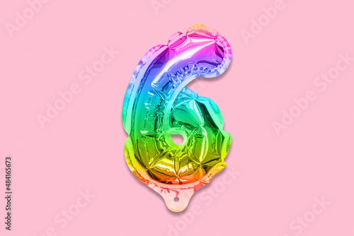 Rainbow foil balloon number, digit six on a pink background. Birthday greeting card with inscription 6. Top view. Numerical digit. Celebration event, template.