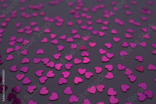 Beautiful heart confetti falling on the Very Peri background. Invitation Template Background design, greeting cards, poster. Valentine's Day.