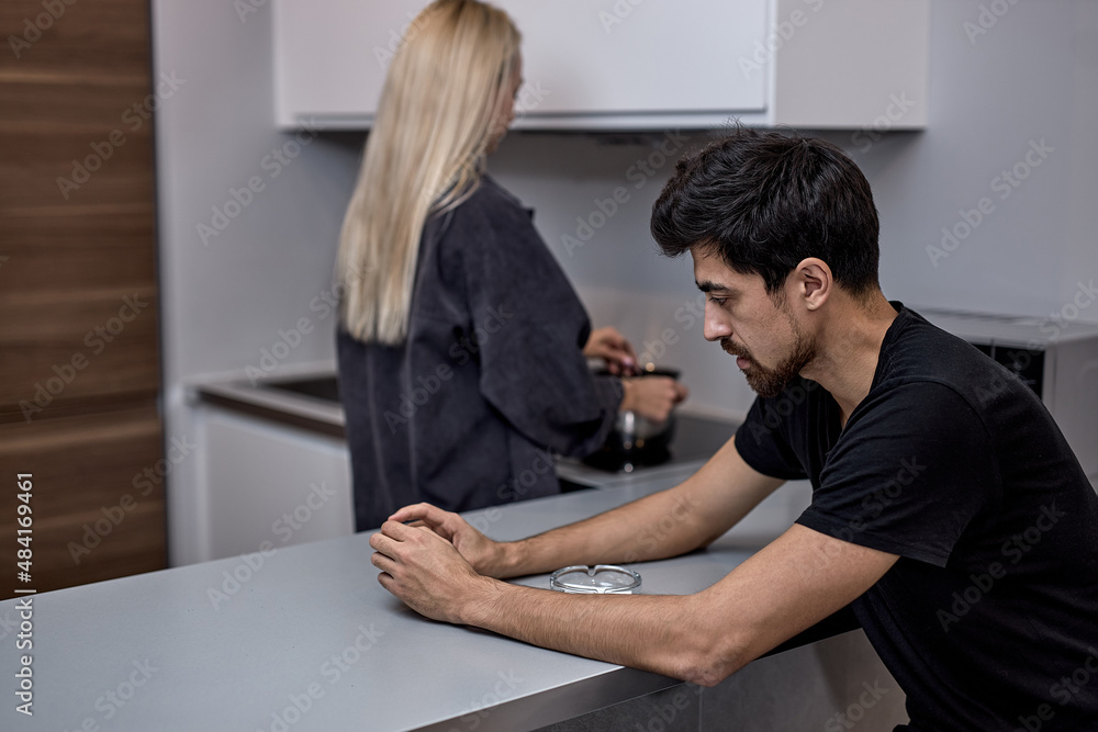 Unhappy young caucasian woman and bearded man not talking after quarrel, in kitchen, frustrated blonde wife and husband ignoring each other, relationship problem, family crisis concept Unhappy young caucasian woman and bearded man not talking after quarrel, in kitchen, frustrated blonde wife and husband ignoring each other, relationship problem, family crisis concept