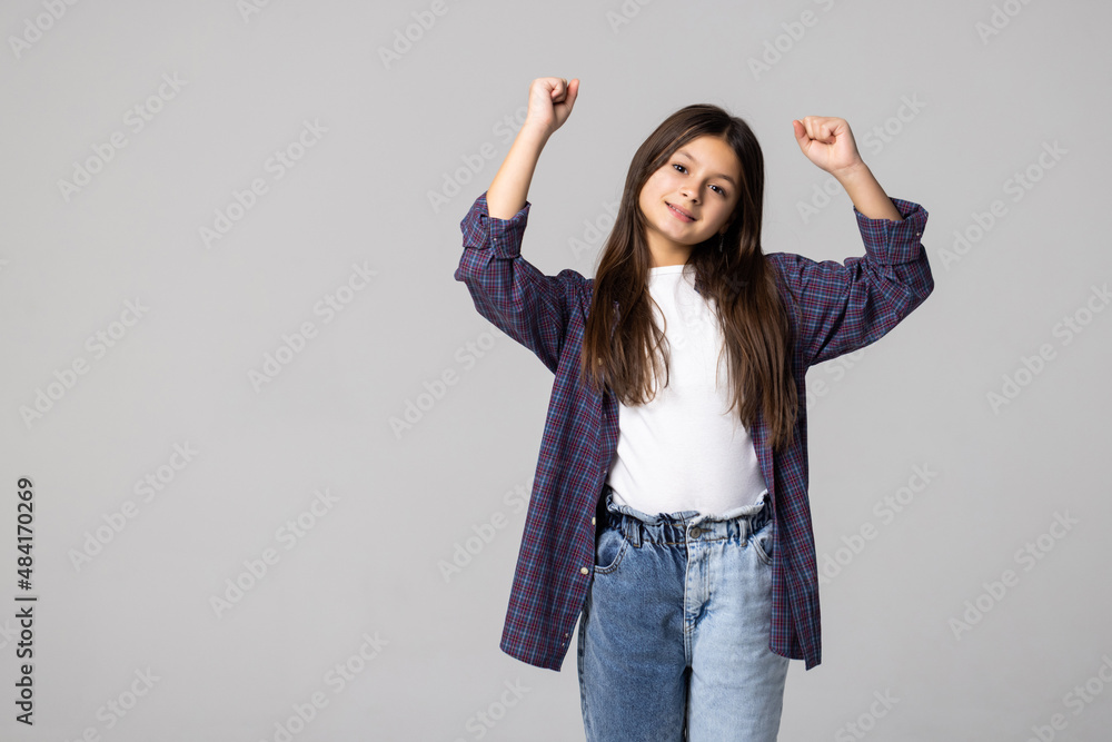 young schoolgirl happy positive with smile rejoices in victory fists hands on gray background