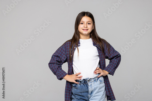 Portrait of a charming brunette little girl isolated on gray background photo