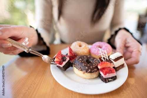 沢山のスイーツを食べる女性 photo