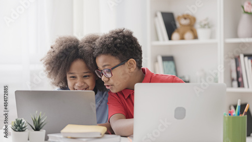 Brother helping with hometask to his little sister, siblings studying at home photo
