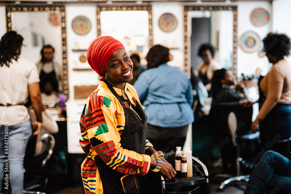 Contemplative female barber looking away in hair salon Contemplative female barber looking away in hair salon