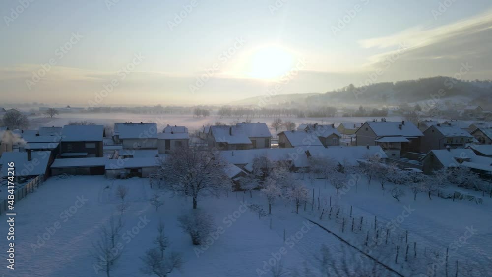 from left to right with drone behind the houses under the snow from left to right with drone behind the houses under the snow