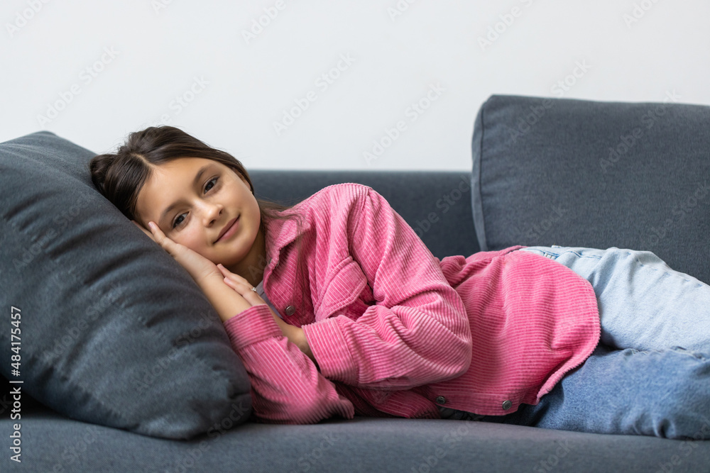 Beautiful school teen girl smile while lying on a sofa in the living room Beautiful school teen girl smile while lying on a sofa in the living room