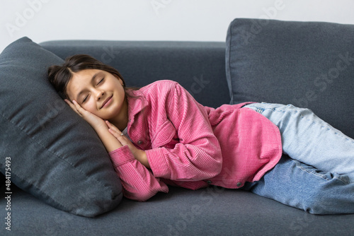 Beautiful teenage school girl sleeping on sofa