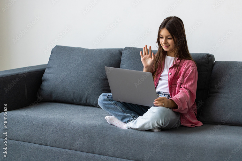 Little school girl using video chat on laptop at home Little school girl using video chat on laptop at home