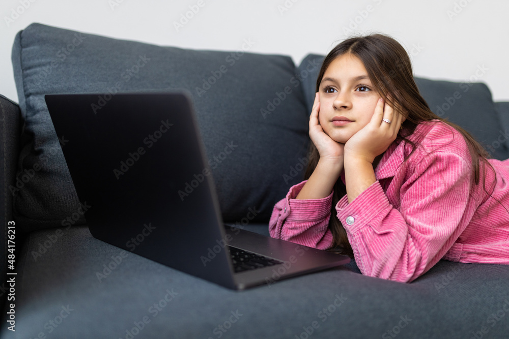 Pretty little teenager girl with laptop sitting on couch Pretty little teenager girl with laptop sitting on couch