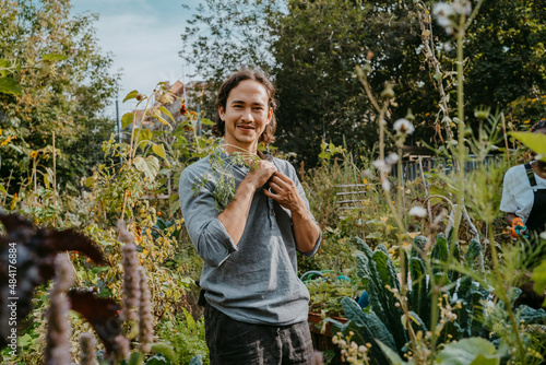 Portrait of smiling male agricultural shareholder with plant in urban garden photo