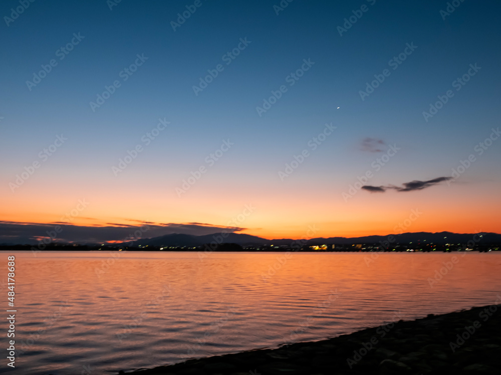 オレンジ色に染まる美しい冬の琵琶湖の夜明け　空のグラデーション