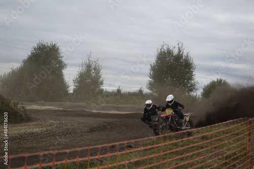 motocross bikers on motorcycles with carrycot