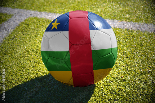 football ball with the national flag of central african republic lies on the green field